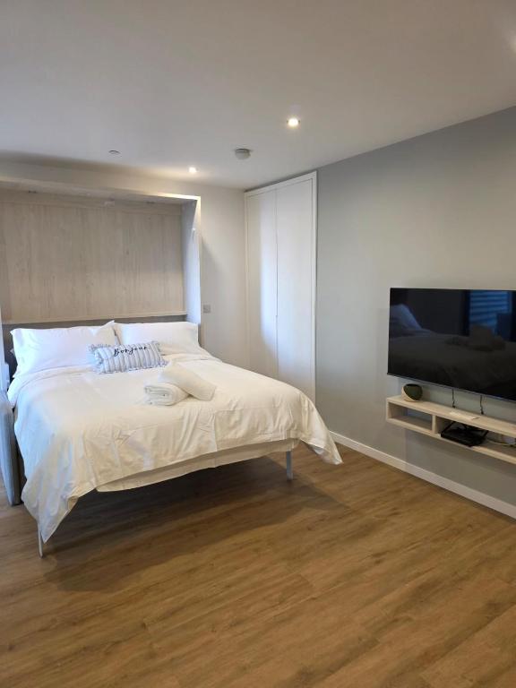 a bedroom with a bed and a flat screen tv at Brand New - Studio Apartment - Self Catering in Gibraltar
