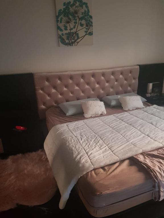 a bedroom with a large bed with a large headboard at le jasmin in El Achour