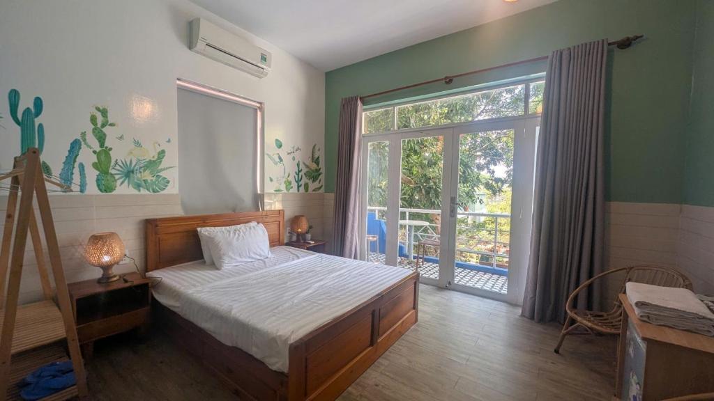 a bedroom with a bed and a large window at Côn Đảo Home in Con Dao