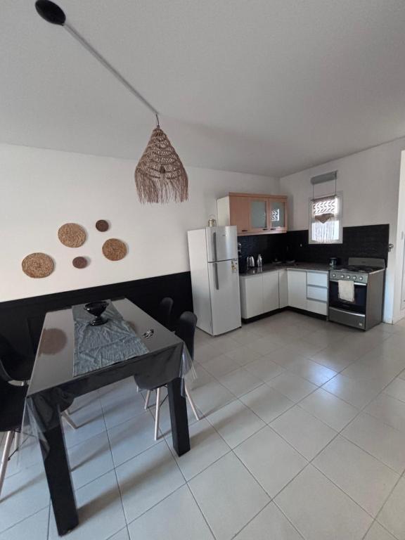 a kitchen with a refrigerator and a table in it at La Serenité en Puerto Madryn in Puerto Madryn