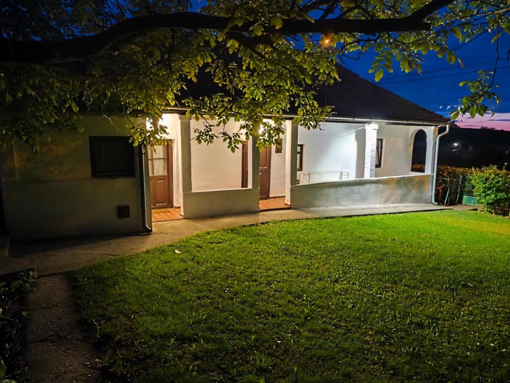 a house with a green lawn in front of it at Szira Porta in Hollókő