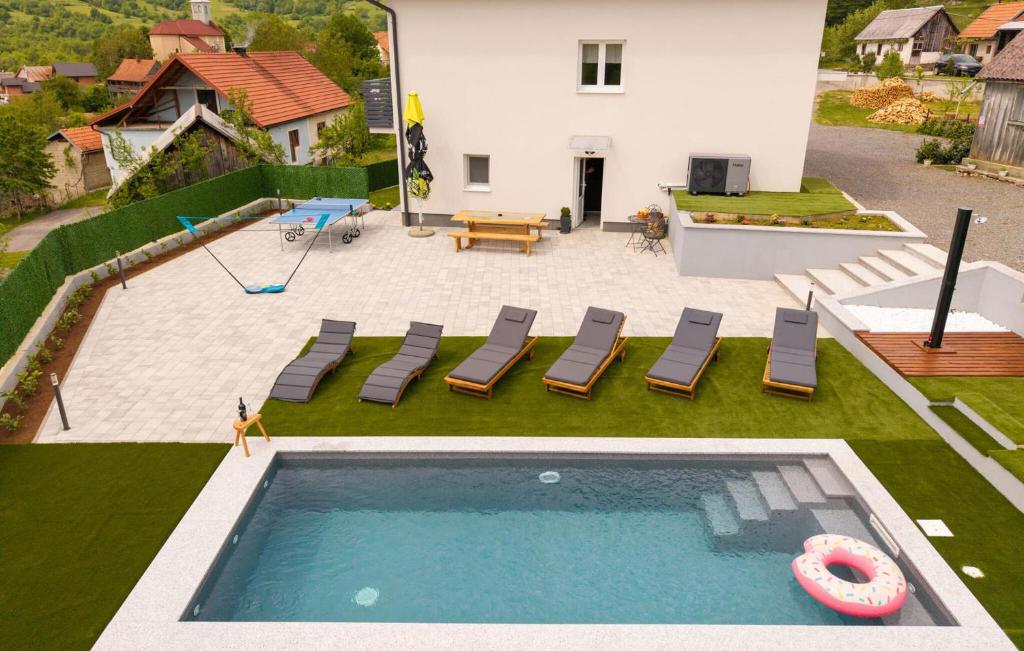 an overhead view of a swimming pool with chairs and a house at Beautiful Home In Otocac in Otočac