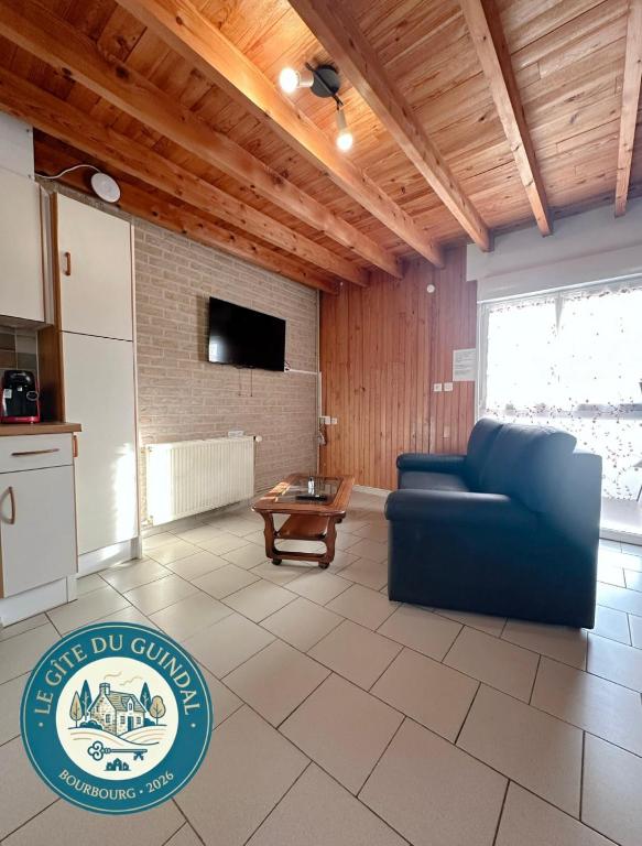 a living room with a blue couch and a tv at Le Gite Zelya in Bourbourg