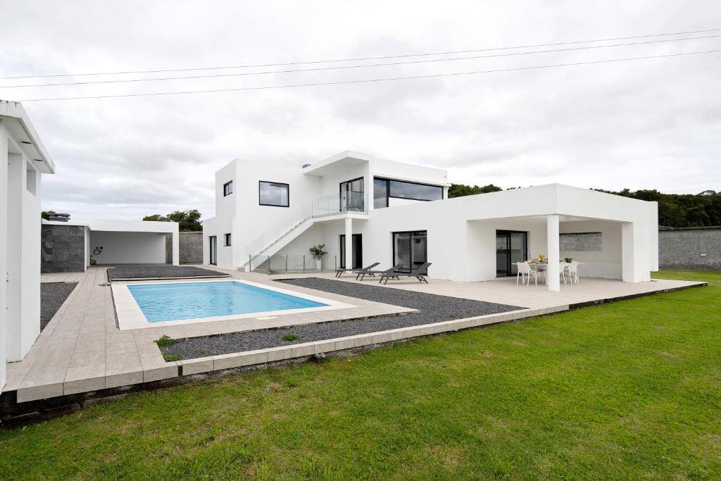 a large white house with a swimming pool at Bella Casa - piso inferior in Angra do Heroísmo