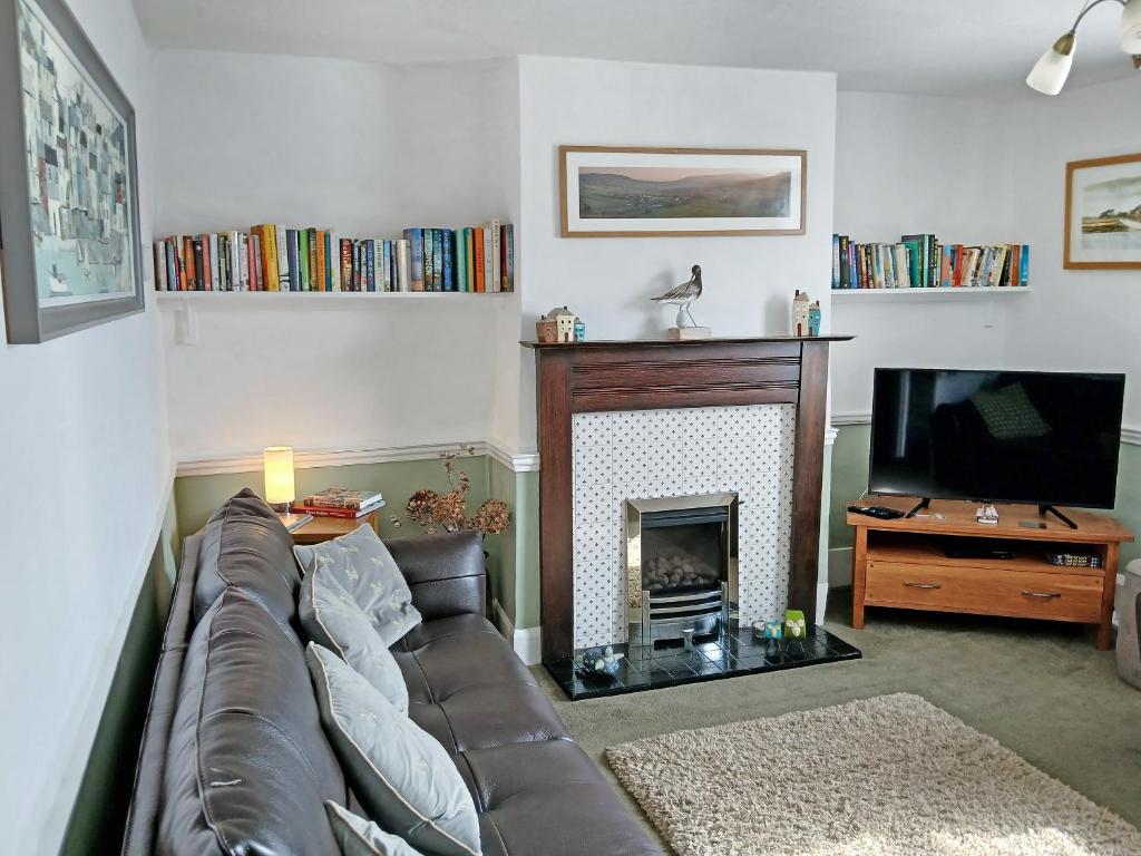 a living room with a couch and a fireplace at Old Town Cottage in Sidmouth