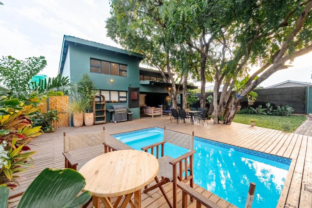 a patio with a table and chairs next to a swimming pool at Wild Villas in Victoria Falls