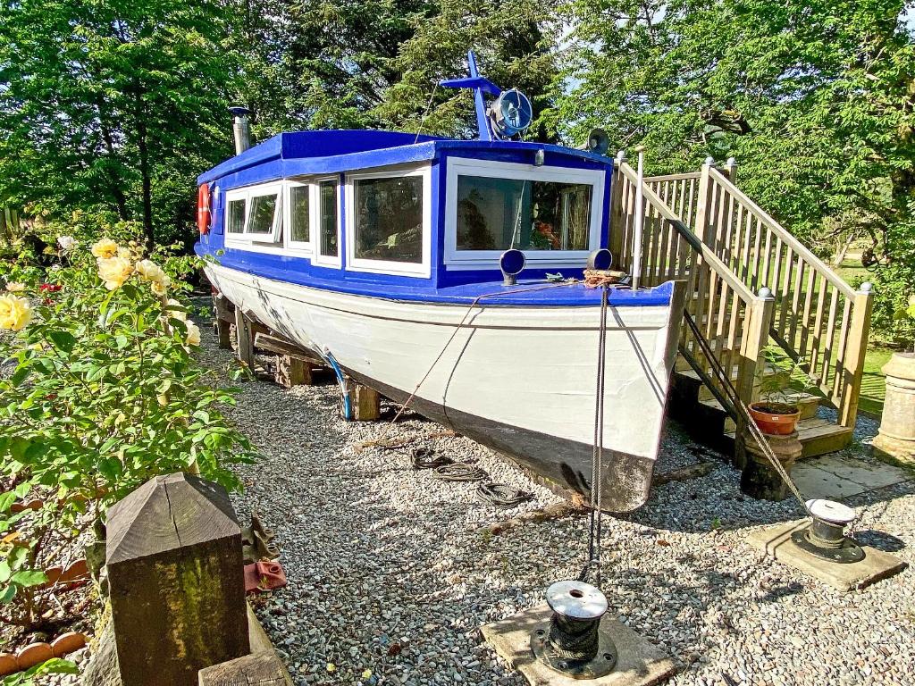 a blue and white boat sitting on the gravel at The Prince - Uk42204 in Clachan of Glendaruel