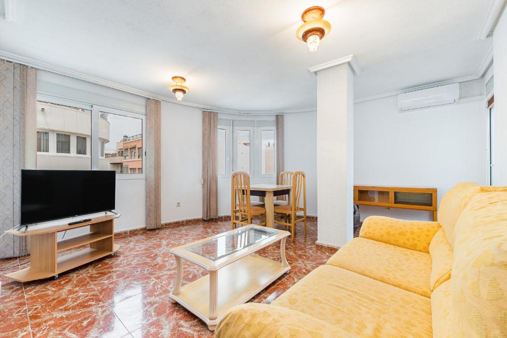 a living room with a couch and a tv and a table at Sunrise Arts 2 in Torrevieja