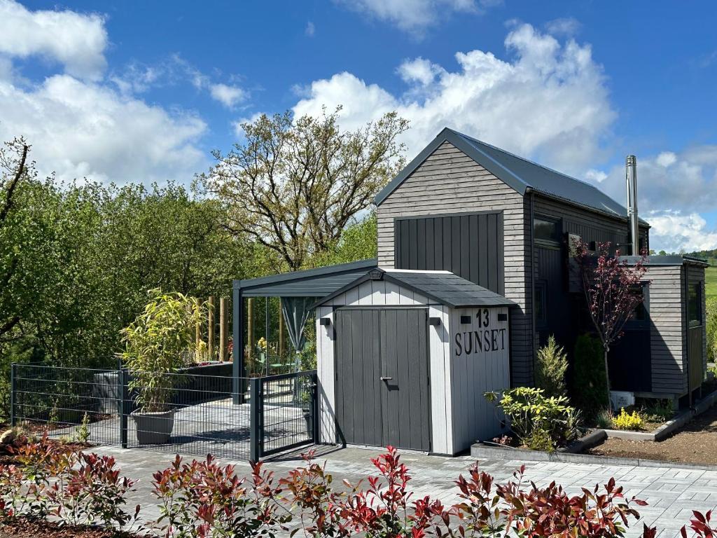 a small shed with a sign on it in a garden at Sunset Tiny House GbR in Neuendorf