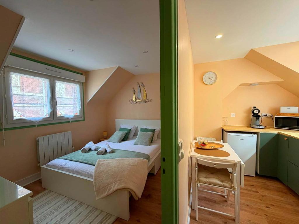 a small bedroom with a bed and a kitchen at Studio LS - Plage, falaise, Funiculaire, in Le Tréport