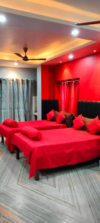 a red bedroom with two beds with red sheets at Howrah Homestay Nidhivan in Howrah