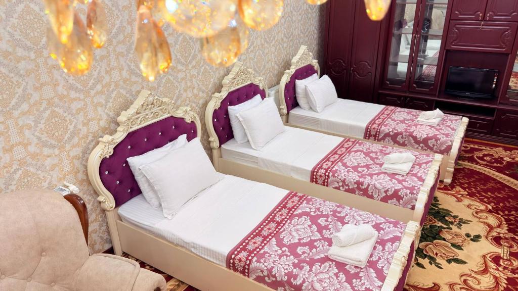 two beds sitting in a room with at Private 3BR House 2 Min Walk to Registan in Samarkand