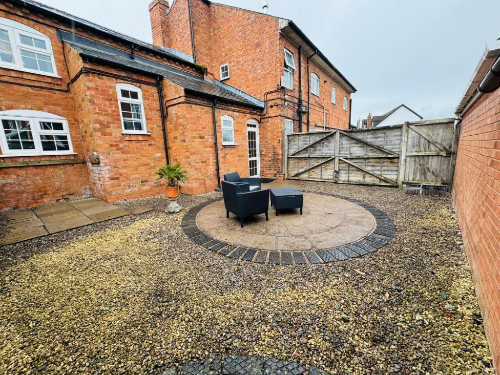 a patio with two chairs and a table in front of a building at sinton House in Bransford