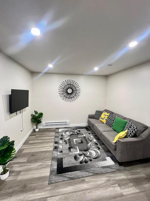 a living room with a couch and a tv at Purplecherry Haven in Regina
