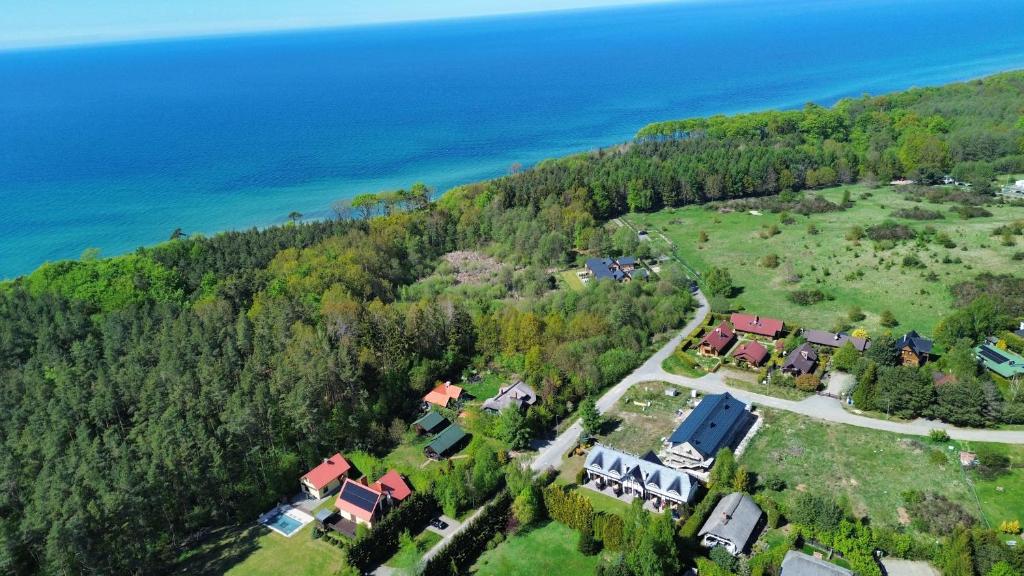 an aerial view of a house on a hill next to the ocean at Willa Świerkowa in Dębina