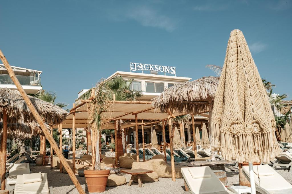 a resort with straw umbrellas and chairs and tables at Jacksons sea view living in Kos