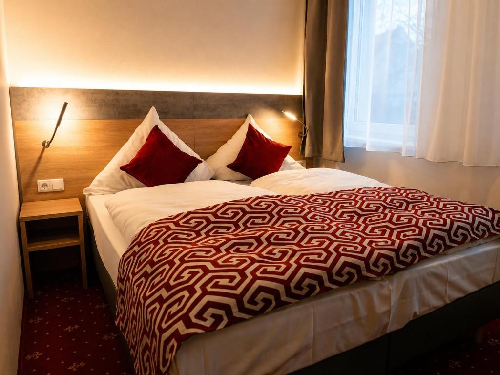 ein Schlafzimmer mit einem großen Bett und roten Kissen in der Unterkunft Hotel Stadion Stadt in Hamburg