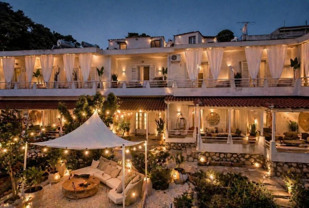 a large white building with a patio at night at Gioula's Residence in Patitiri