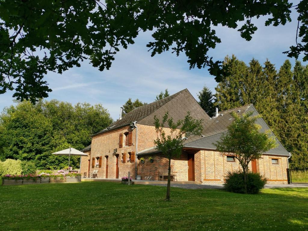 an old brick building with a tree in the yard at La Croix Bala in Signy-le-Petit