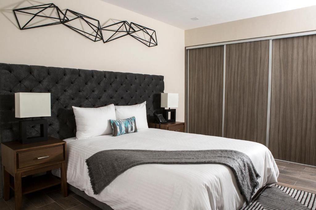 um quarto com uma cama grande e uma cabeceira preta em Suites Rio Elba em Cidade do México