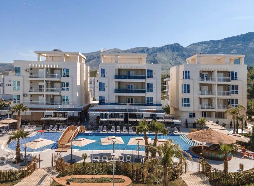 a resort with a swimming pool and some buildings at Paradise Apartment Radhime in Radhimë