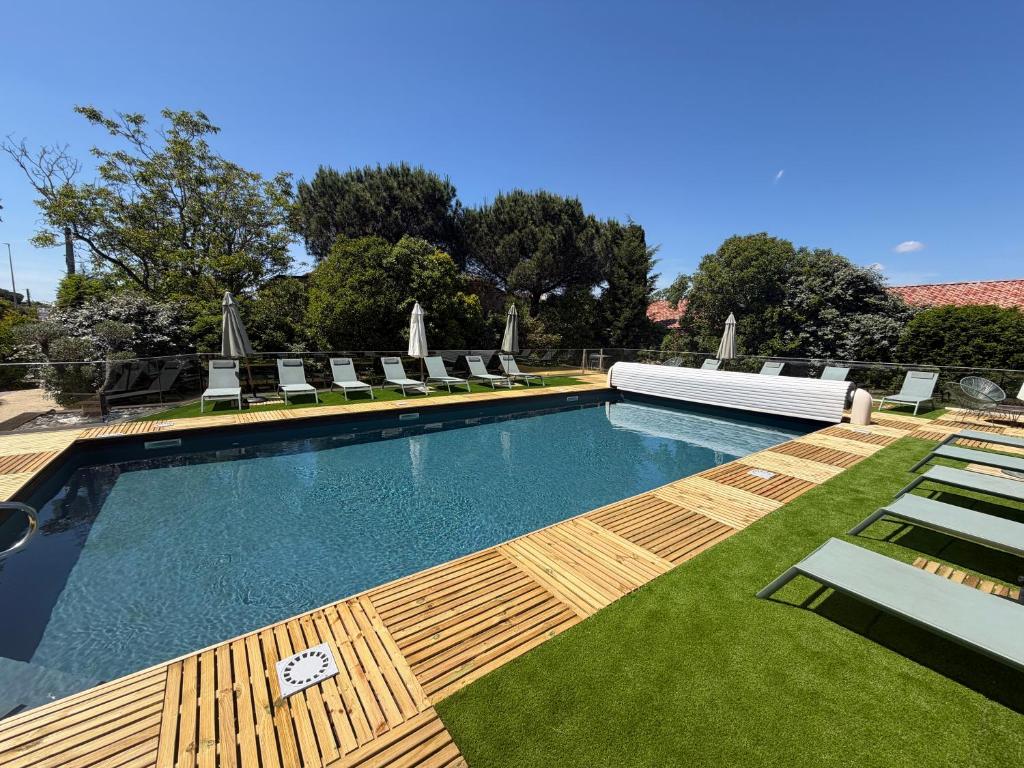 a swimming pool with chaise lounge chairs and sidx sidx sidx at Résidence de Diane - Toulouse in Toulouse