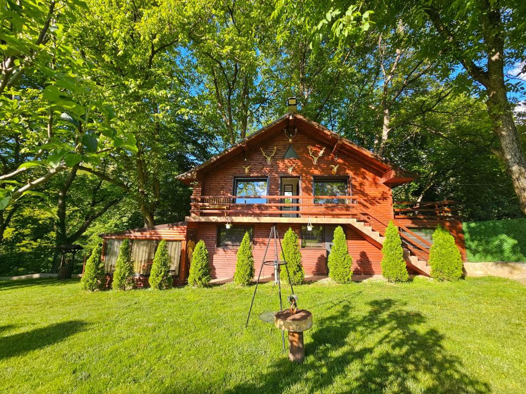 a log cabin with a statue in front of it at Вила ОРЕХИТЕ in Dupnitsa