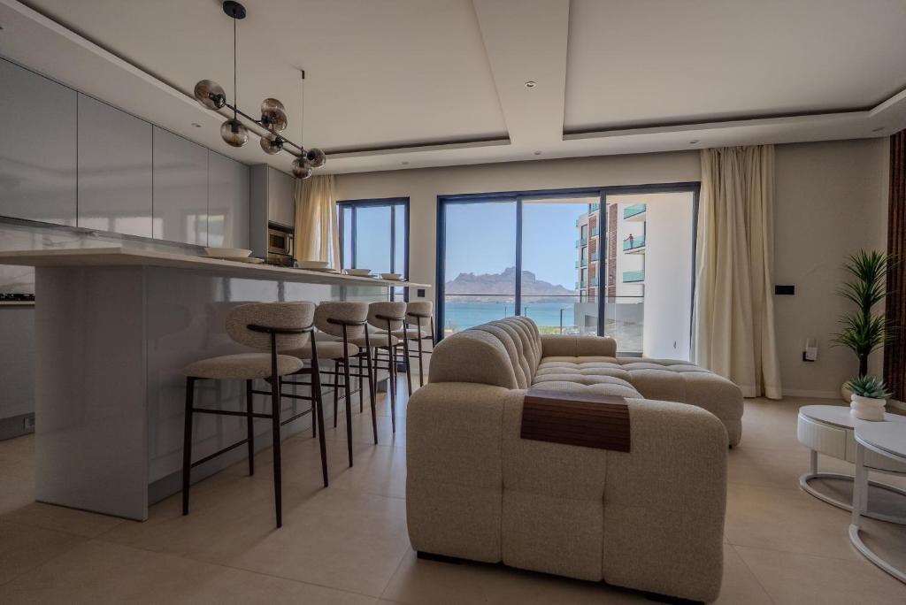 a kitchen and living room with a couch and chairs at Sharksproperties Luxury 3BR Ocean View Apartment with Rooftop Pool 6 Guests in Mindelo