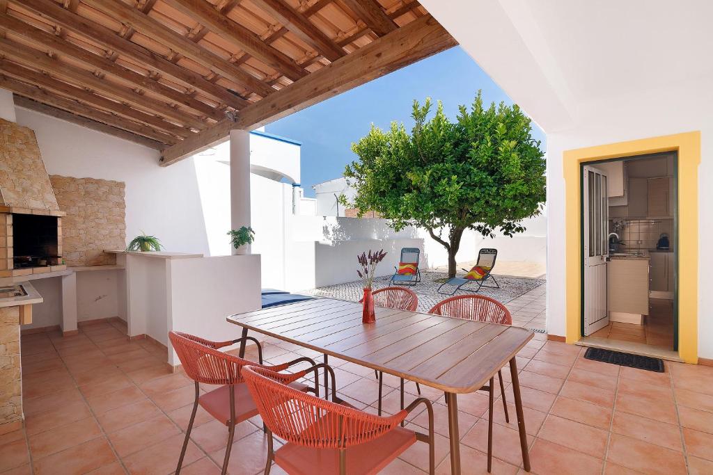 a kitchen and dining room with a wooden table and chairs at Modern Villa In Olhao in Quelfes
