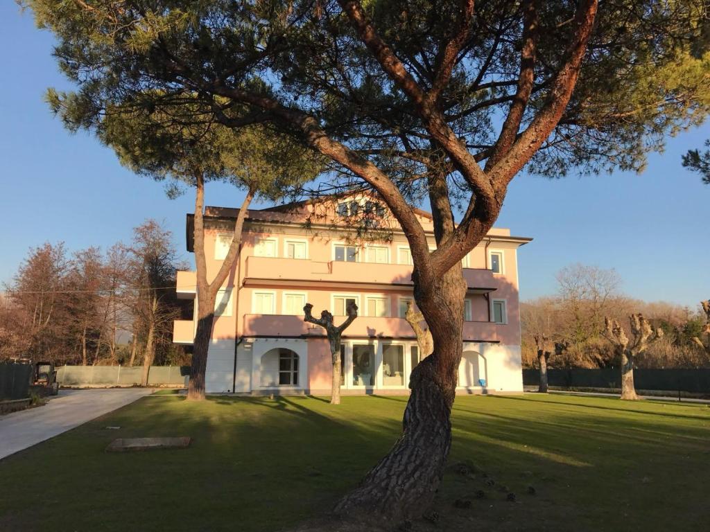 a large house with a tree in front of it at I tre platani in Marina di Massa