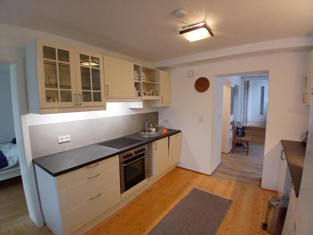 a kitchen with white cabinets and a black counter top at Wein4tel Auszeit in Blumenthal