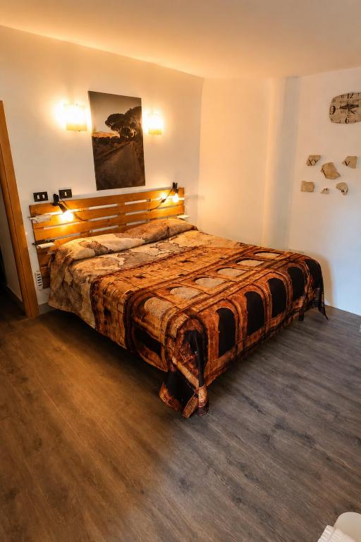 a bedroom with a large bed with a wooden headboard at Casina Appia Antica in Marino