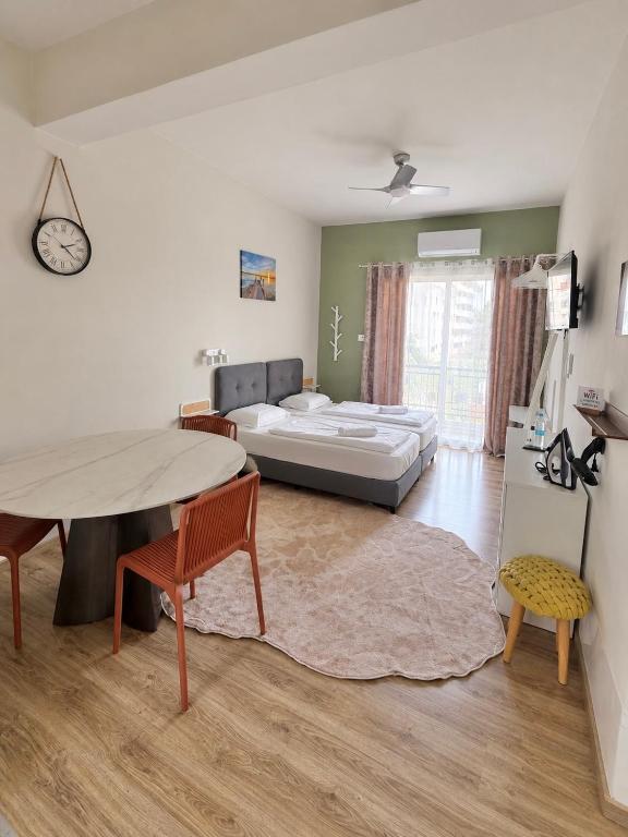 a living room with a bed and a table and chairs at Smart Deluxe Studio N9 private Kitchenette Balcony Beach 250m Marina Port 900m in Limassol