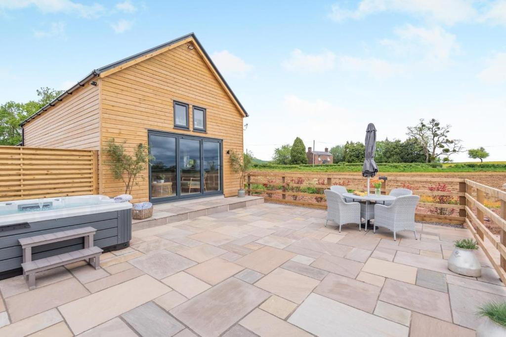 a patio with a hot tub and a table at 2 Bed in Blakeney oc-m42455 in Awre