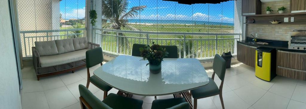 a table and chairs in a kitchen with a balcony at Apartamento - Resort Golf Ville in Aquiraz