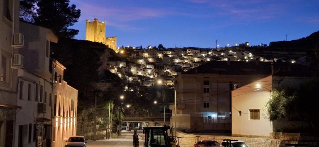 a view of a city at night with a castle at Eclipse del Júcar Luna in Alcalá del Júcar