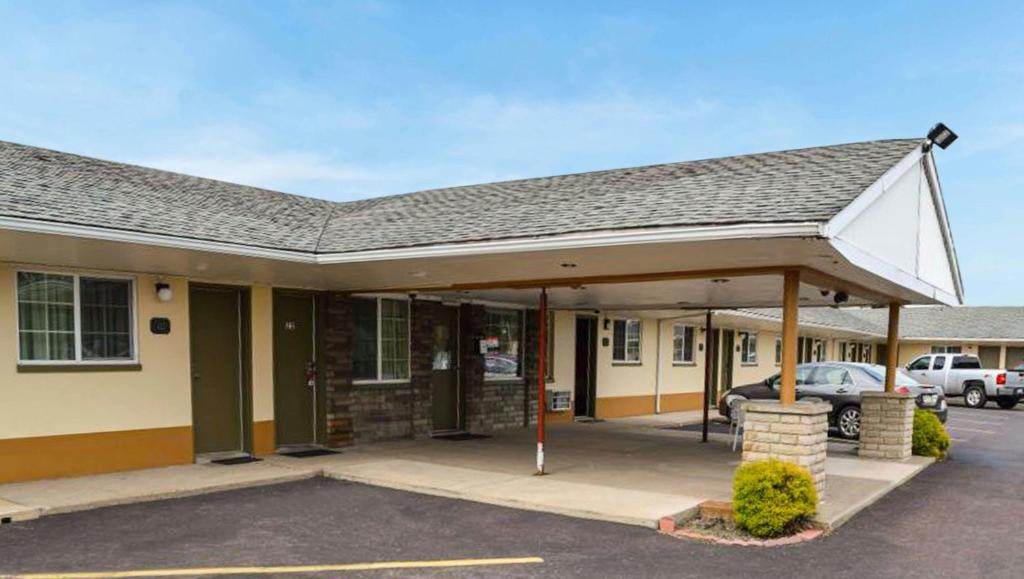 a building with a car parked in a parking lot at Relax Inn Bloomsburg in Bloomsburg
