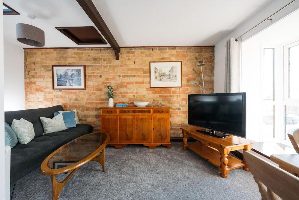 a living room with a couch and a flat screen tv at 2 Bed in Thurleigh oc-o42689 in Thurleigh