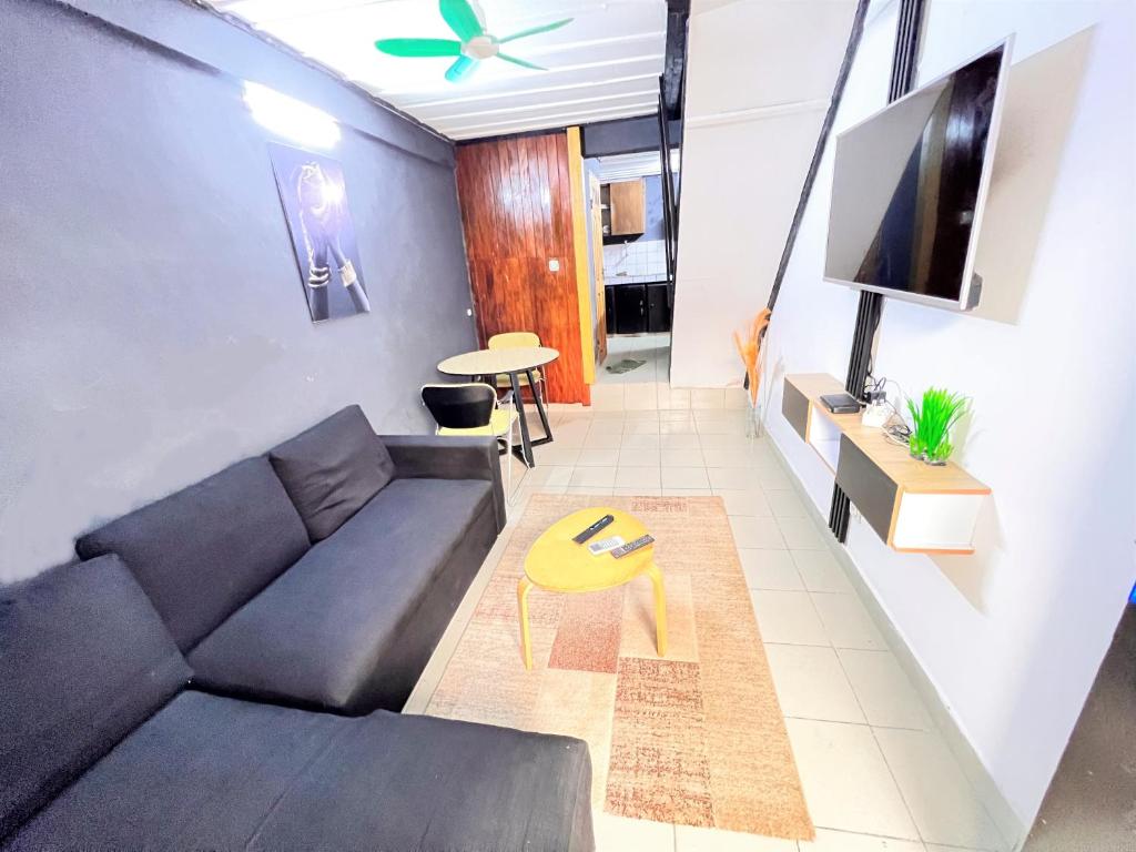 a living room with a couch and a tv at The Yafé Bastos 5 in Yaoundé