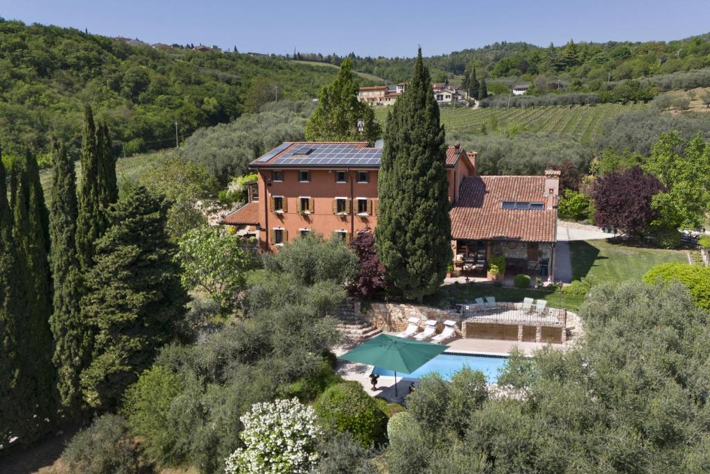 an aerial view of a house with a swimming pool and trees at Villa Terrarossa with Pool in the Vineyard in Mezzane di Sotto