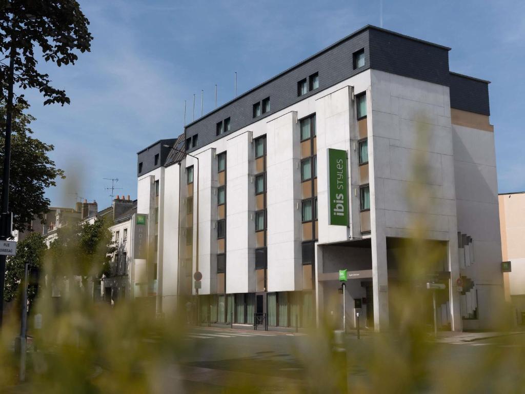 ein großes weißes Gebäude mit einem grünen Schild darauf in der Unterkunft ibis Styles Angers Centre Gare in Angers