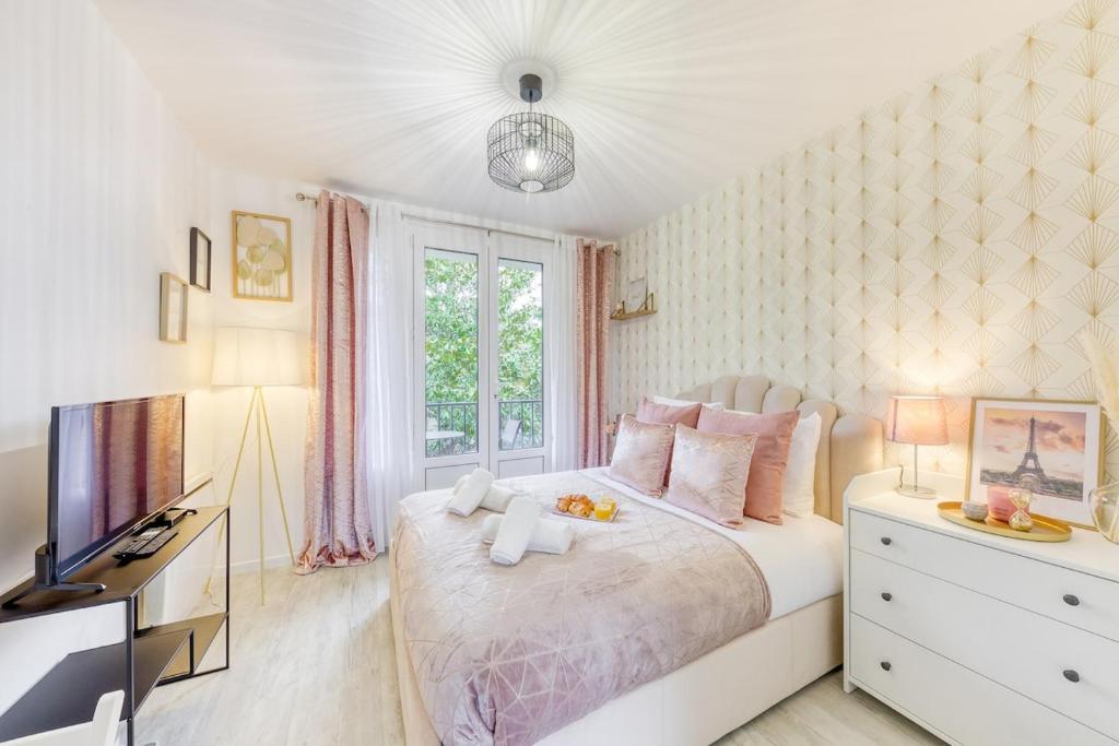 a bedroom with a white bed and a television at Parking free - cosy & elegant in LʼHay-les-Roses