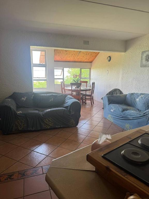 a living room with two couches and a table at Retro at The Vaal - entire Flat in Denysville