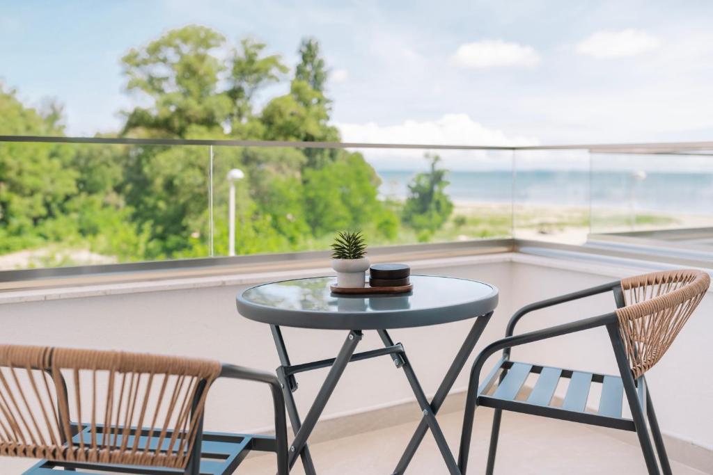 a table and two chairs on a balcony with a window at NUA Apartments in Ulcinj