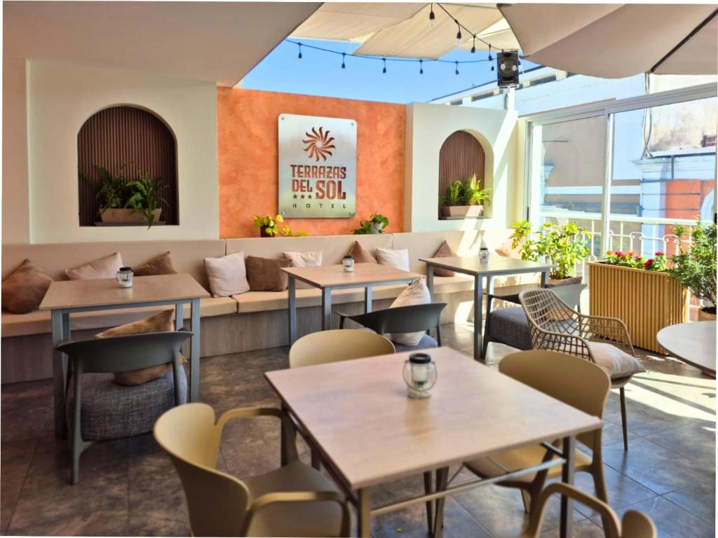 a restaurant with tables and chairs and a bench at Hotel Terrazas del sol in Arequipa