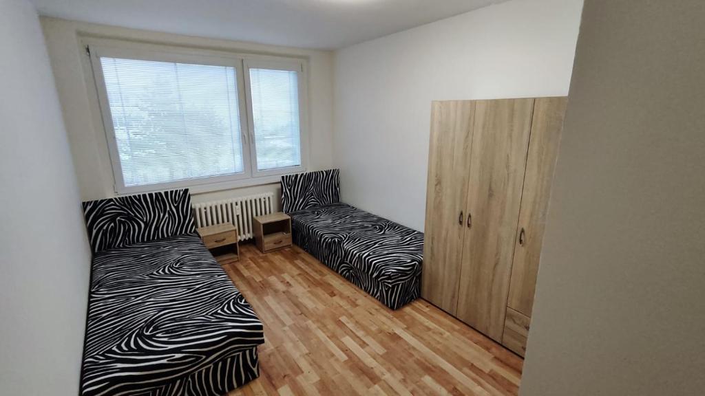 a living room with two beds and a window at Apartmán pro 6 osob, Most M2 in Most