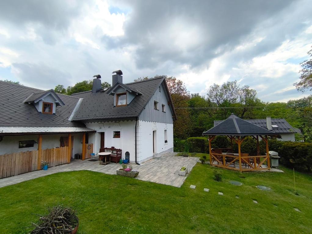 a white house with a patio and a gazebo at Penzion U Ovečky in Jeseník