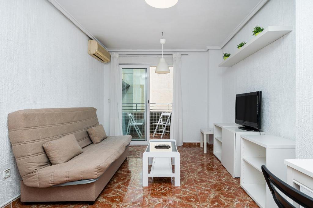a living room with a couch and a tv at Sunrise Arts 1 in Torrevieja
