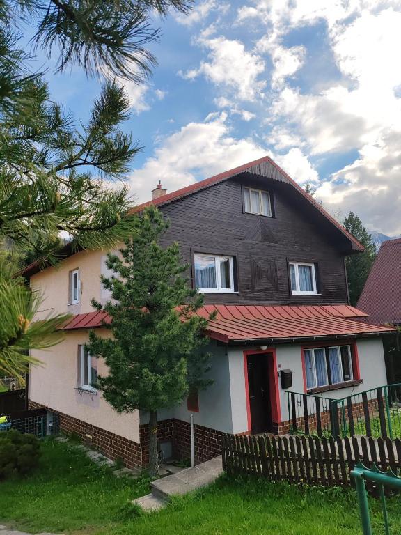 a house with a red roof and a tree at ZorHouse Ždiar in Ždiar