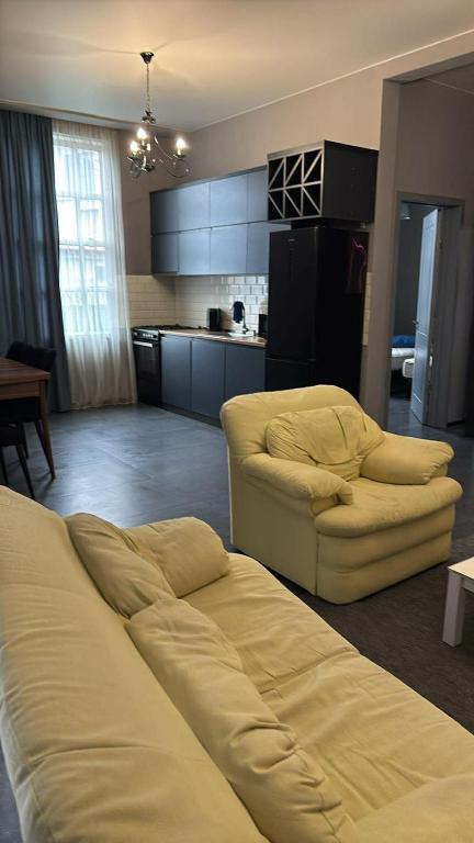 a living room with a couch and a kitchen at Mari's Villa in Batumi